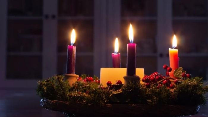 Burning advent wreath with five candles.