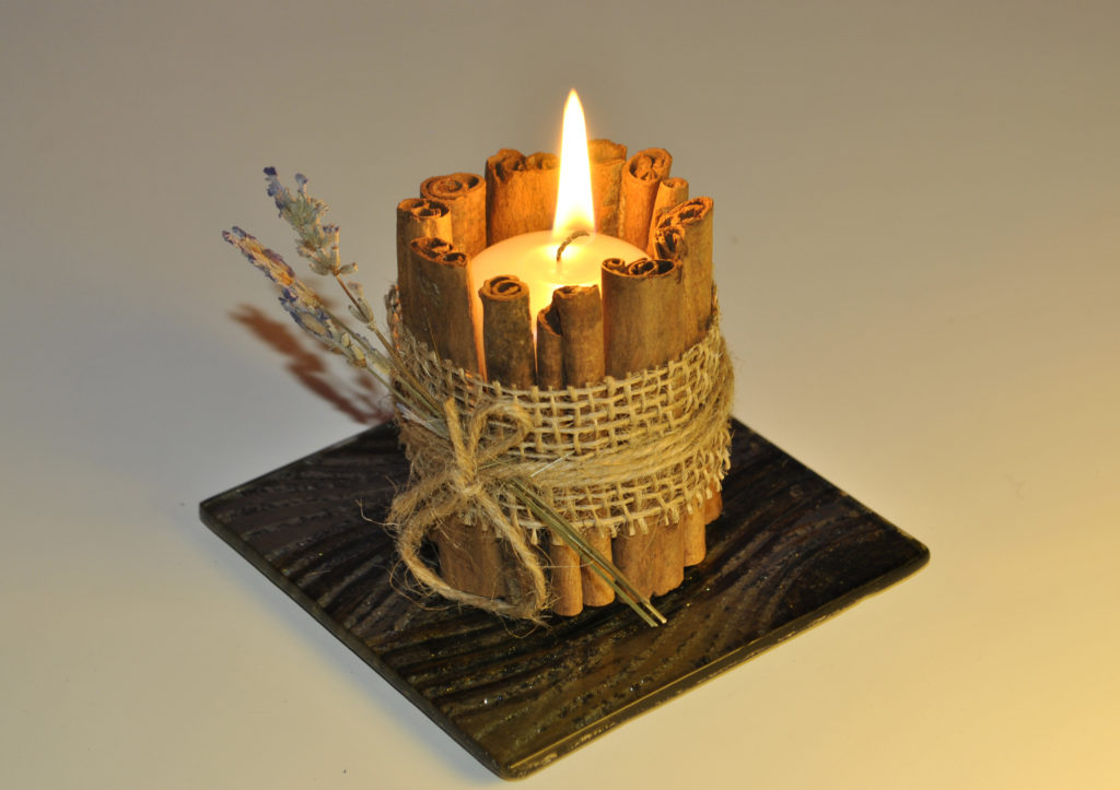 A candle in a cinnamon candlestick.