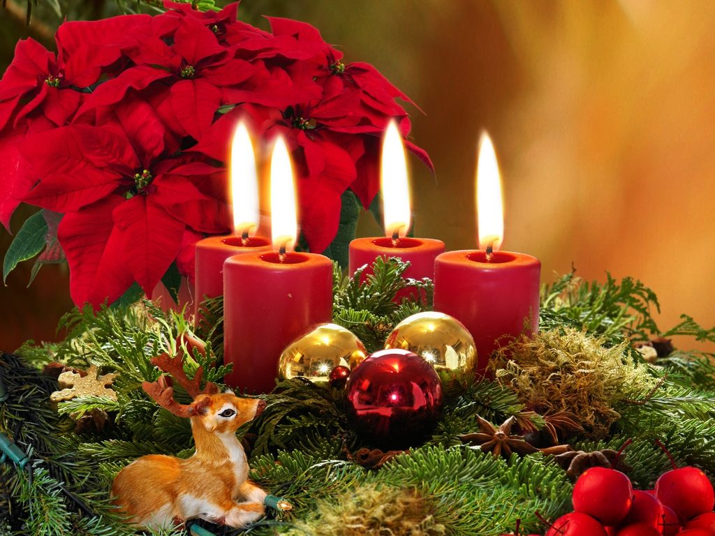 Advent wreath with four burning red candles.