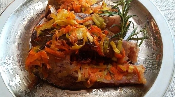 Baked carp on vegetables and butter