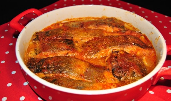 Carp on black beer in a red baking dish