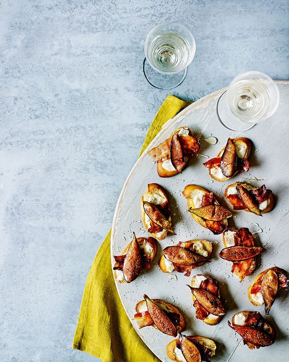 A plate full of small appetizers with fresh figs.