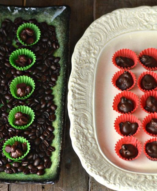 Christmas cookies with coffee beans, covered in chocolate, served in green and orange paper cups.