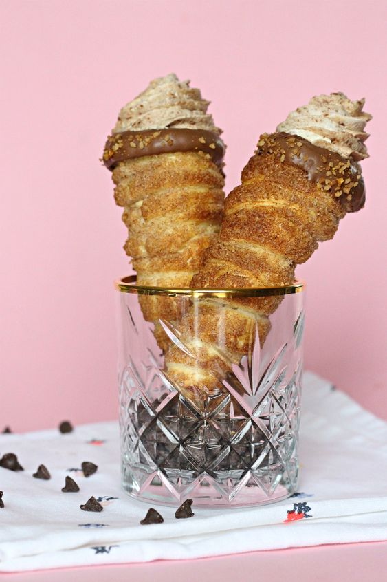 A glass filled with two tubes with cream and chocolate.