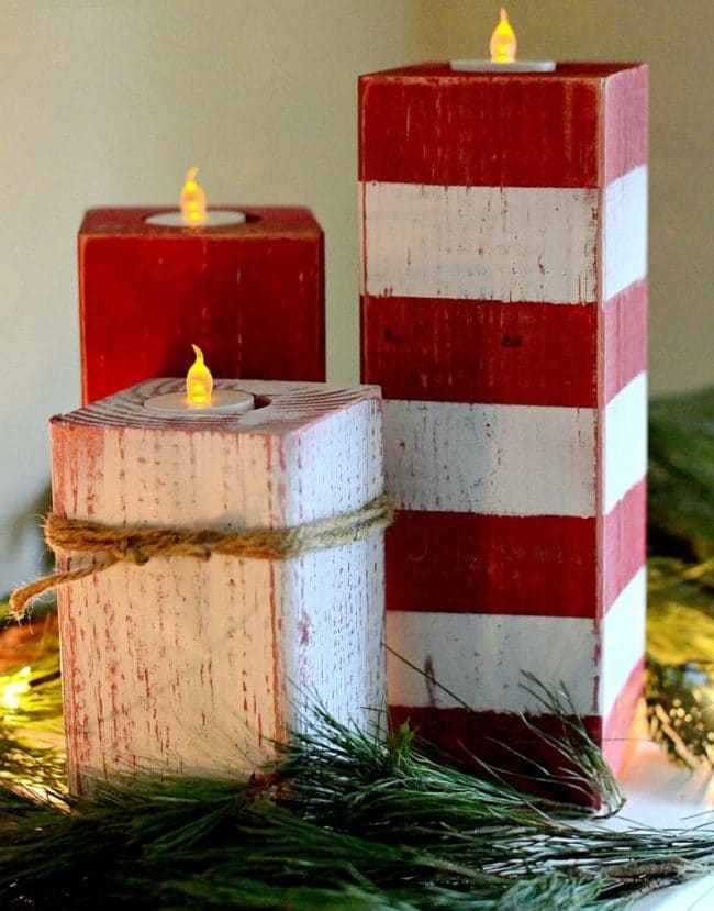 Wooden Christmas candlestick made of cubes in red and white design with electric candles