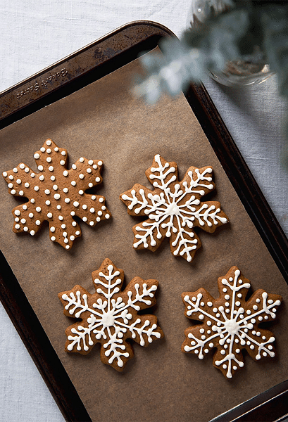 decorated gingerbread cups in the shape of flakes on a sheet