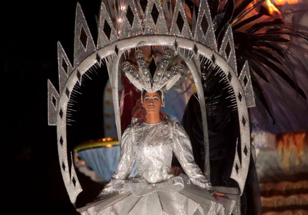 A woman dressed in a festive Christmas outfit for a parade.