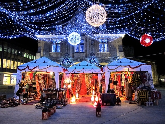 Three decorated stands with Christmas ornaments.