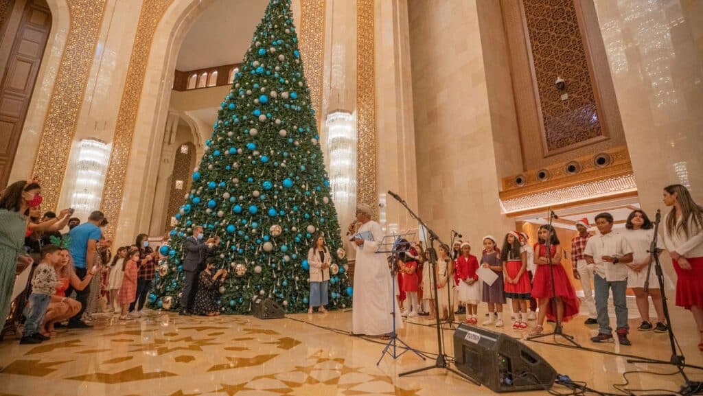 A large Christmas tree and a group of singing children.