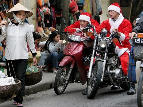 Two Santa Clauses on a motorcycle.