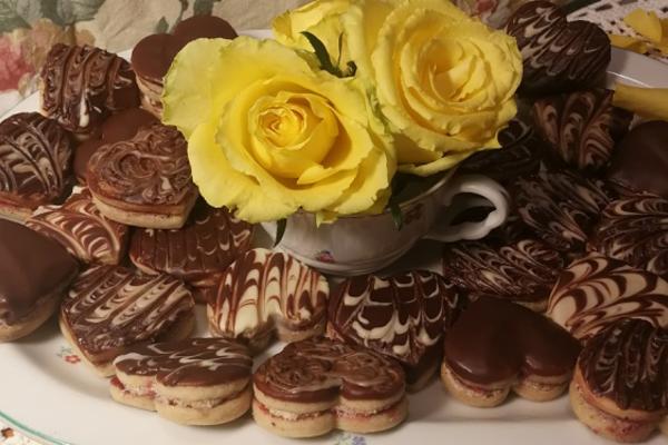 Christmas coffee cookies, in the shape of a heart, decorated with cream.