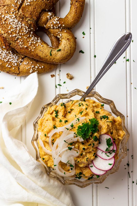 A bowl full of soft cheese spread decorated with radish.