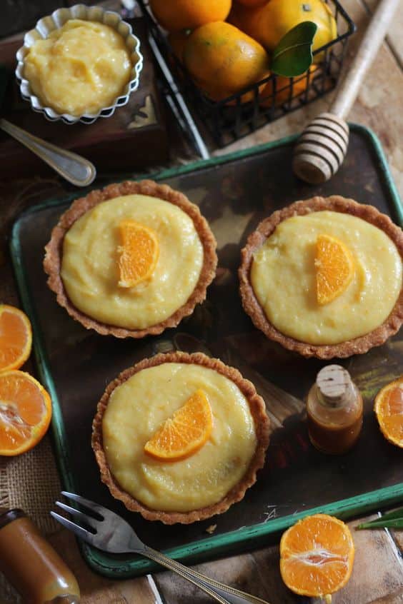 Cupcakes filled with tangerine cream and decorated with a piece of fruit.