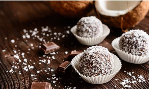 Balls with gingerbread spices decorated with coconut in paper cups.