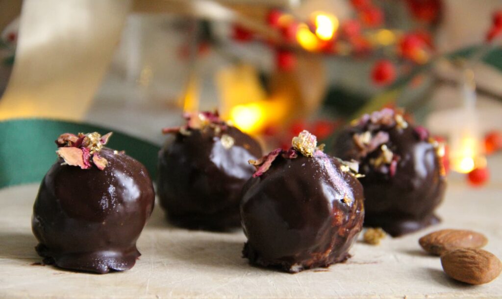 Unbaked balls of mascarpone, coconut, almond butter and gingerbread spice filled with roasted almonds and covered in dark chocolate.