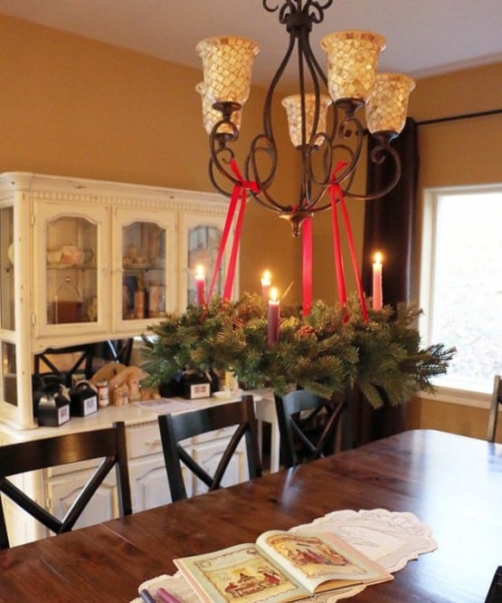 Advent wreath hanging on a chandelier.