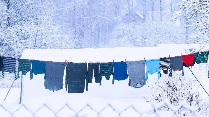 Laundry hanging on a line outside in the snow.