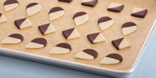 Marzipan sweets in the shape of drops and diamonds, half decorated with chocolate coating.