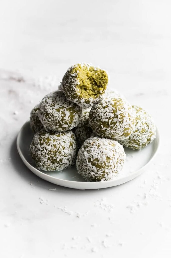 Christmas green balls wrapped in coconut on a plate.