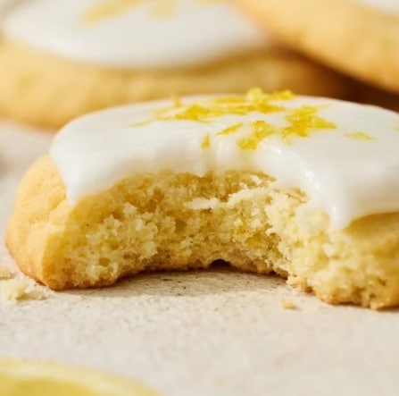 A cookie in the shape of a marigold with a lemon glaze