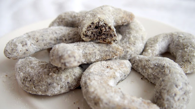 Baked poppy seed Christmas rolls on a plate and sprinkled with sugar.