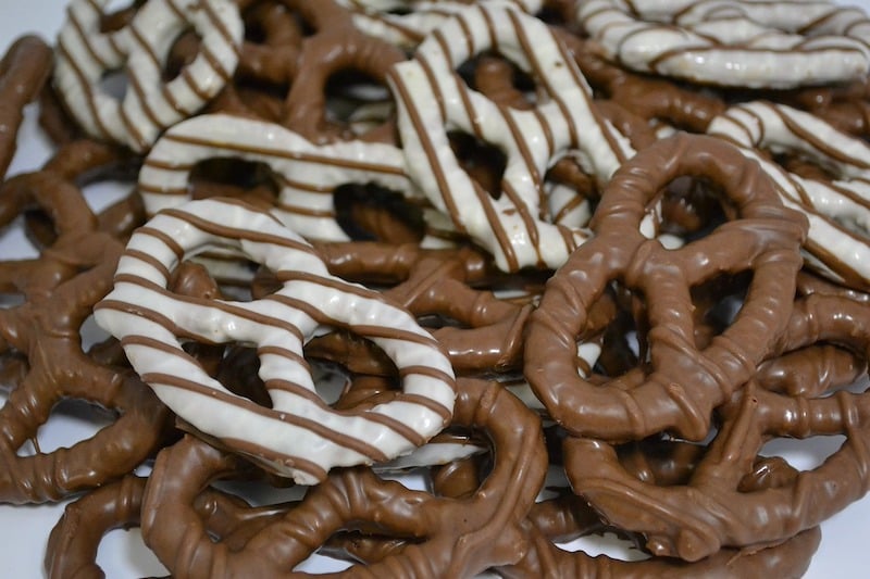 Chocolate pretzels on a plate, alternating chocolate decorations.