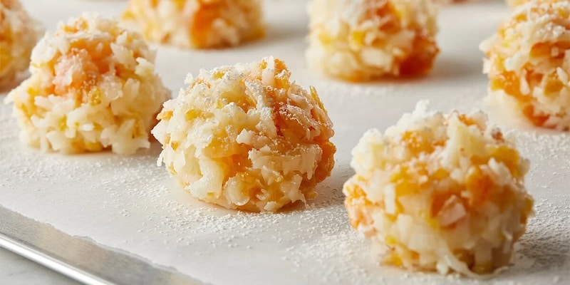 Apricot balls with oatmeal on a white tray.