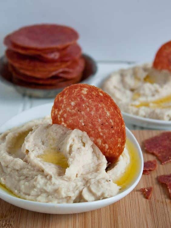 Cream spread on sandwiches with melted cheese and hard salami.