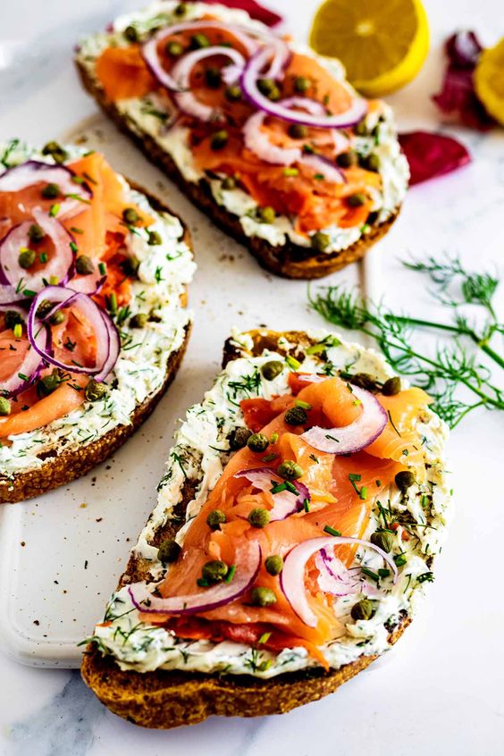 Delicious sandwich with smoked salmon decorated with capers and onions.