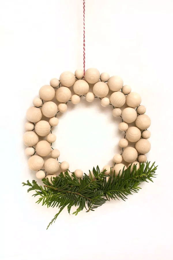 Minimalist Advent wreath for the door made of wooden balls in a Nordic style.