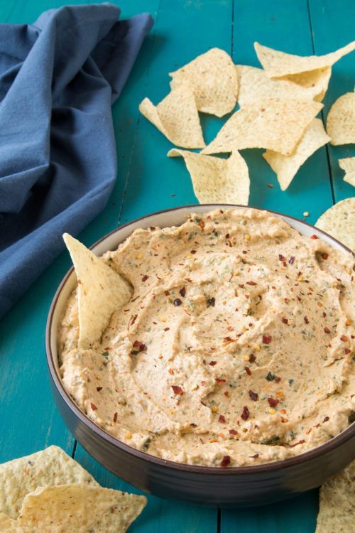 A bowl of creamy spread with chilli flakes on top.