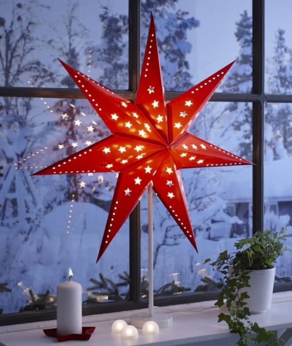 Illuminated red Christmas star outside the window