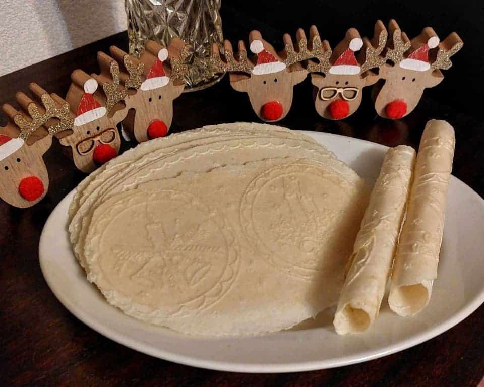 Fragile wafers and tubes on a plate, next to it is a Christmas decoration.