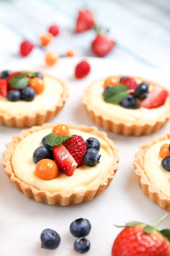 Line cakes filled with vanilla cream and decorated with fruit.