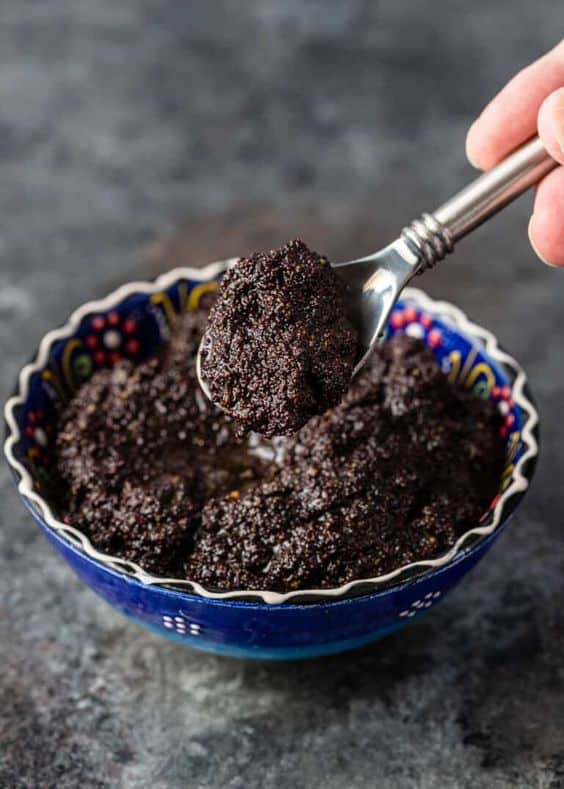 A bowl full of creamy poppy seed filling with dried fruit.