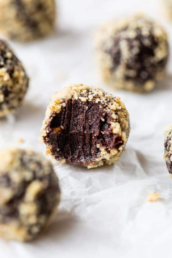 Unbaked balls full of chocolate and nuts on the surface.