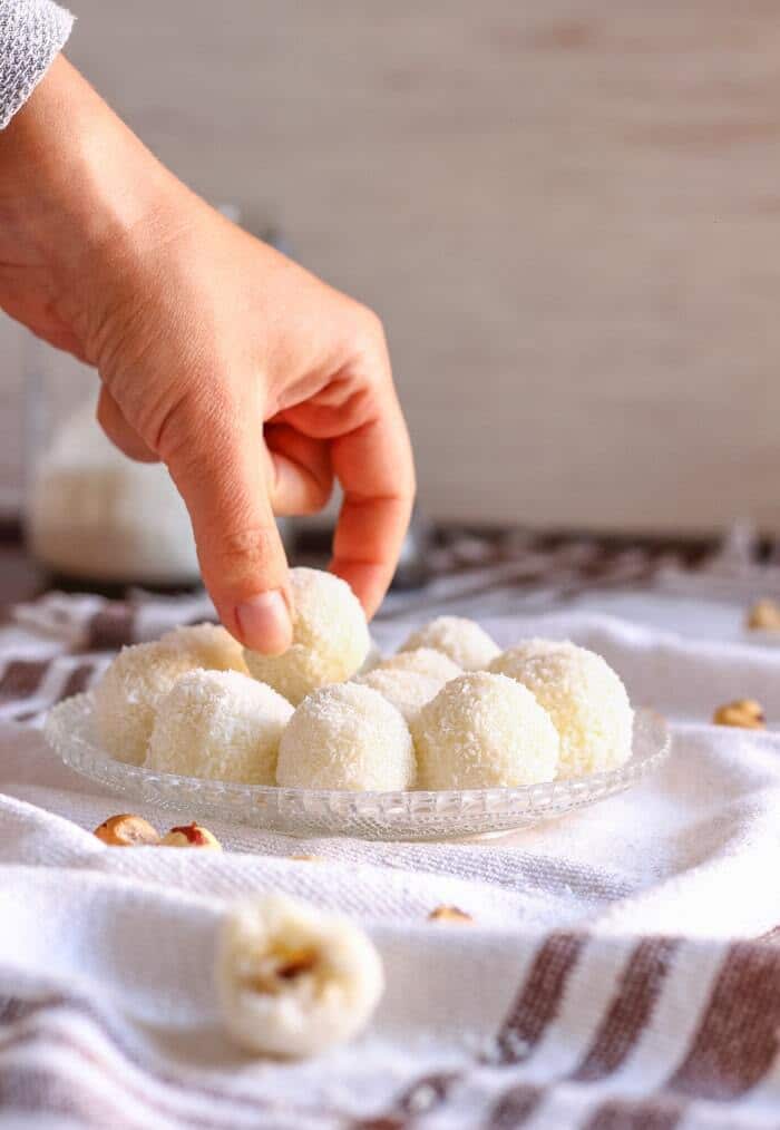 Raffaello marbles on a tray and a hand taking one marble.