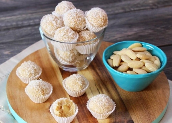 Coconut balls with almonds in paper cups.