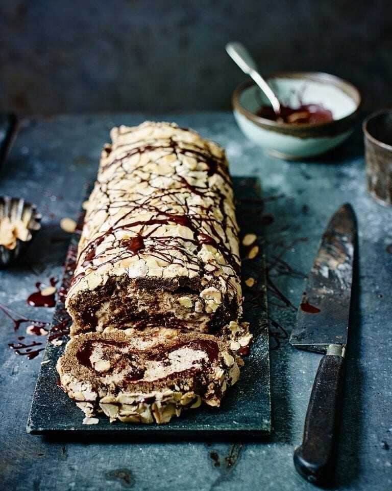 Meringue roll with chocolate and coffee with a knife next to it.