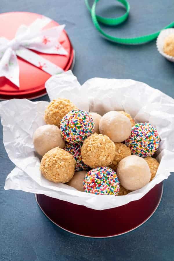 Peanut balls in a bowl lined with baking paper.