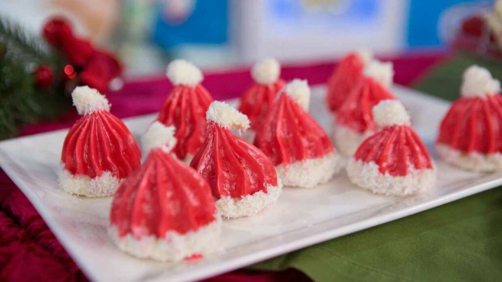 Christmas meringues in the shape of Santa Claus caps on a plate.