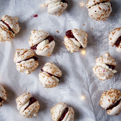 Snow meringues with coconut filled with fluffy whipped cream and cranberries.