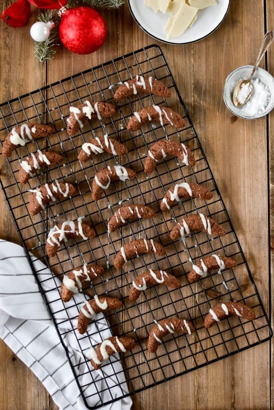 Almond rolls drizzled with glaze placed on a rack.