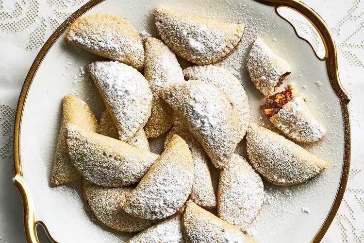 Christmas crescents filled with cherry jam, boiled grape must and candied lemon on a plate.